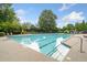 Beautiful community pool with lounge chairs and umbrellas surrounded by mature trees at 1235 Renaissance Se Ct, Mableton, GA 30126