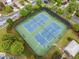 Aerial view of two community tennis courts with fresh blue surface and surrounding greenery at 1235 Renaissance Se Ct, Mableton, GA 30126