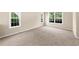 Carpeted bedroom featuring two large windows with tree-filled backyard views and neutral walls at 3559 Reservoir Pass, Acworth, GA 30101