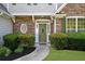 Inviting front entrance with stone detailing and a decorative wreath on the green door at 3559 Reservoir Pass, Acworth, GA 30101