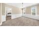 Bright living room with neutral carpet, paneled wainscoting, and modern chandelier at 3559 Reservoir Pass, Acworth, GA 30101