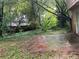 Backyard view with overgrown greenery and patio area at 5035 Chadwick Ct, Decatur, GA 30035