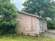 View of the side of a house with siding and overgrown greenery at 5035 Chadwick Ct, Decatur, GA 30035