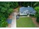 Aerial view of a one-story home, with well-maintained lawn and landscaping, nestled in a lush, green, wooded area at 5930 Shannon Drive Dr, Cumming, GA 30040