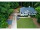 Aerial view of home featuring well-maintained lawn, wooded property, and driveway at 5930 Shannon Drive Dr, Cumming, GA 30040