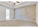Spacious bedroom featuring tray ceiling and brick accent wall at 5930 Shannon Drive Dr, Cumming, GA 30040