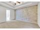 Spacious bedroom with a tray ceiling and brick accent wall at 5930 Shannon Drive Dr, Cumming, GA 30040