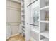 Bright closet featuring white shelving units, wood floors, and a window at 5930 Shannon Drive Dr, Cumming, GA 30040