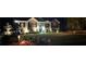 Night view of single-story home with manicured lawn and landscaping, highlighted by exterior lighting at 5930 Shannon Drive Dr, Cumming, GA 30040