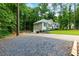Charming single-story home with a well-manicured lawn, gravel parking and a long driveway surrounded by lush trees at 5930 Shannon Drive Dr, Cumming, GA 30040