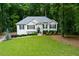 Charming one-story home boasts a lush green lawn and beautiful landscaping, surrounded by mature trees at 5930 Shannon Drive Dr, Cumming, GA 30040