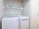 Efficient laundry area with a new washer and dryer and floating shelf at 5930 Shannon Drive Dr, Cumming, GA 30040