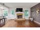 Open-concept living room with hardwood floors, stone fireplace, and designer accent wall at 5930 Shannon Drive Dr, Cumming, GA 30040