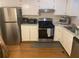 Galley kitchen featuring stainless steel appliances, white cabinetry, and modern countertop, providing a functional cooking space at 8955 Stonebridge Blvd, Douglasville, GA 30134