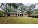 A home with a white brick back exterior surrounded by lush greenery and a spacious lawn at 1127 Renee Dr, Decatur, GA 30035