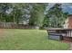 Sprawling backyard with mature trees, a wooden fence, and a wooden deck with seating area at 1685 Frazier Park Dr, Decatur, GA 30033