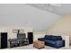 Bright bonus room with neutral carpet, a vaulted ceiling, and a blue couch with a full entertainment system at 1685 Frazier Park Dr, Decatur, GA 30033