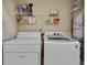 Functional laundry room with white appliances and shelving for storage at 1685 Frazier Park Dr, Decatur, GA 30033