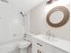 Well-lit bathroom with a tub/shower combo, round mirror, and vanity sink at 17 Ivy Gates Ne, Atlanta, GA 30342