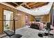View of a basement with wood paneling, carpeting, weightlifting equipment, and a stone fireplace at 504 Rock Meadow Dr, Stone Mountain, GA 30088