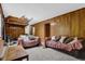 View of a basement with wood paneling, carpeting, and couches covered in blankets at 504 Rock Meadow Dr, Stone Mountain, GA 30088