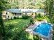 Aerial view showcasing the in-ground pool, lush backyard, and the home's layout surrounded by greenery at 5357 Highway 81, Loganville, GA 30052