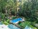 Aerial view of a private backyard oasis with a pristine pool and mature trees surrounding the property at 5357 Highway 81, Loganville, GA 30052