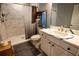 Modern bathroom featuring marble tile shower and white vanity with countertop sink at 5357 Highway 81, Loganville, GA 30052
