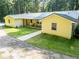 Exterior view of the charming yellow home with metal roof and covered porch at 5357 Highway 81, Loganville, GA 30052