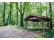 Rustic pavilion in wooded area with an open design and a gravel base perfect for outdoor relaxation and entertaining at 5357 Highway 81, Loganville, GA 30052