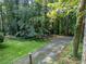 Manicured lawn featuring mature trees and a driveway creates a serene setting enhancing the home's curb appeal at 5357 Highway 81, Loganville, GA 30052