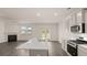 Open kitchen with stainless appliances, island, and an adjacent living area with fireplace at 320 Aspen Valley Dr, Loganville, GA 30052