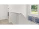 This staircase has white walls, plush carpet, and abundant natural light from a nearby window at 414 Oak View Ln, Dallas, GA 30157