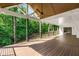 Covered deck with an open-beam ceiling, modern fan, and string lights overlooking the lush green backyard at 4201 Brookview Se Dr, Atlanta, GA 30339
