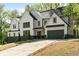 Stunning two-story modern home with a sleek black roof, white siding, and a well-manicured front lawn at 4201 Brookview Se Dr, Atlanta, GA 30339
