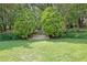 Backyard features lush landscaping, a tiered stone walkway, and mature trees, offering privacy at 5154 Meadowbrook Cir, Suwanee, GA 30024