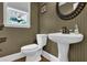 Small bathroom featuring a pedestal sink, decorative mirror, and wallpapered walls at 5154 Meadowbrook Cir, Suwanee, GA 30024