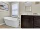 Elegant bathroom featuring a freestanding tub with modern fixtures and a vanity with countertop space at 5154 Meadowbrook Cir, Suwanee, GA 30024