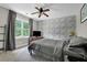 Stylish bedroom with neutral decor, a patterned accent wall, and a window with natural light at 5154 Meadowbrook Cir, Suwanee, GA 30024