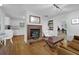 Cozy living area with hardwood floors, brick fireplace, and access to kitchen and dining room at 5154 Meadowbrook Cir, Suwanee, GA 30024
