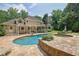 Incredible backyard with pool, spa, and stone patio offers a perfect outdoor retreat and complements the home at 5154 Meadowbrook Cir, Suwanee, GA 30024