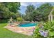 Backyard oasis features a beautiful pool with a stone waterfall feature and flagstone patio, perfect for entertaining at 5154 Meadowbrook Cir, Suwanee, GA 30024