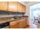 The kitchen has wood cabinets, granite countertops, stainless steel sink and subway tile backsplash at 1150 Collier Nw Rd # G8, Atlanta, GA 30318