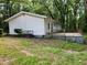 Rear exterior view of home, featuring a small patio and a yard surrounded by lush greenery at 3705 Orchard Dr, Atlanta, GA 30349