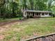 Front exterior view of home with mature tree coverage throughout the property and plenty of yard space at 3705 Orchard Dr, Atlanta, GA 30349
