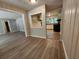 Open-concept living space with wood-look floors, leading into a kitchen with white cabinets and modern appliances at 3705 Orchard Dr, Atlanta, GA 30349
