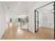 Open-concept foyer with hardwood floors, staircase, and black framed glass doors leading to a private office at 3735 Hamilton Mill Rd, Buford, GA 30519