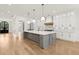 Spacious kitchen with a large island, stainless appliances, white cabinets, and hardwood flooring at 3735 Hamilton Mill Rd, Buford, GA 30519