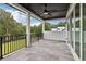 Spacious covered patio with a ceiling fan, black railing, stone floor, and great view of the green backyard at 3735 Hamilton Mill Rd, Buford, GA 30519