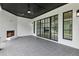 Covered patio with a fireplace, brick walls, tiled floor, black ceiling, and large glass doors at 3735 Hamilton Mill Rd, Buford, GA 30519